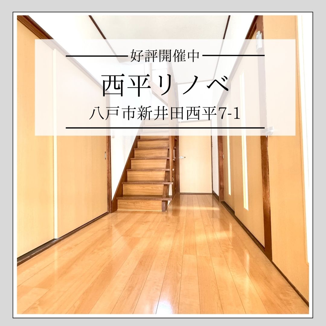 温かみのある玄関ホール。木製の床、階段、両側に引き戸がある。