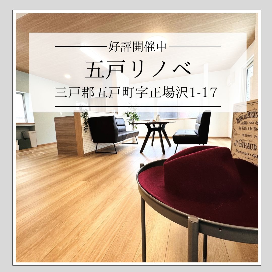 シンプルでスタイリッシュな日本のリビングルーム。キッチン、ダイニングテーブル、そしてサイドテーブルに置かれたフェドーラハットとリキュールの本。
